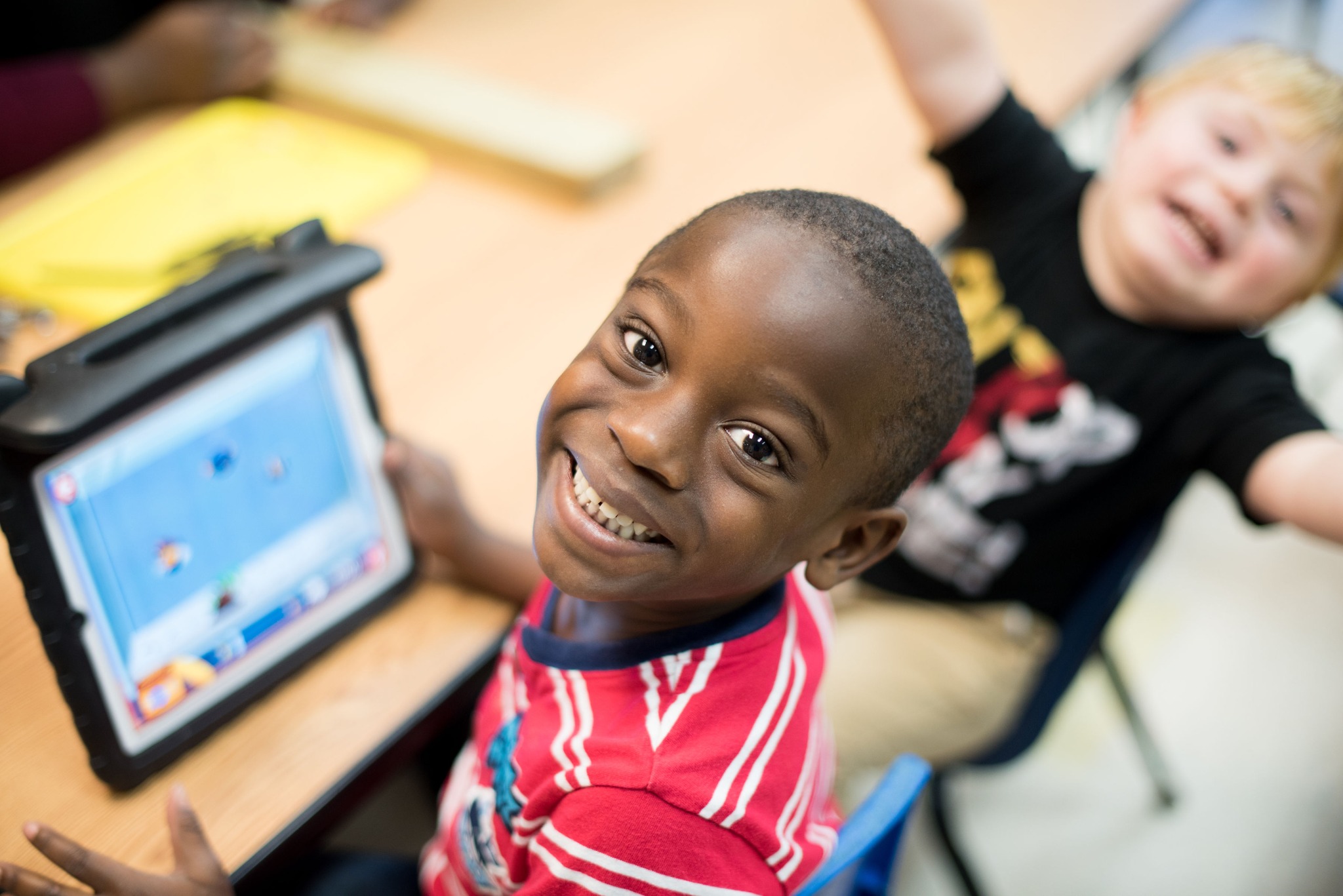 A smiling child using assistive technology at Easterseals